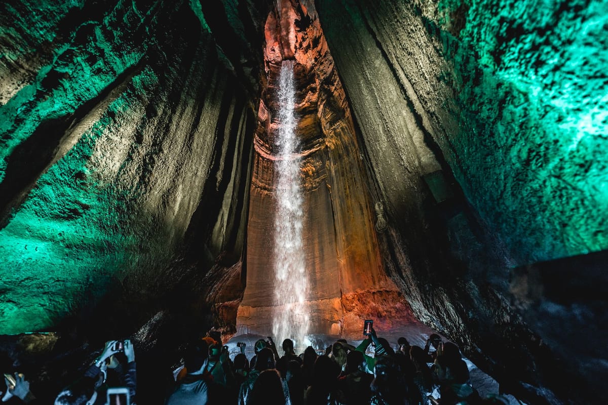 A group of people look at Ruby Falls,A group of people look at Ruby Falls many pointing phones at the falls